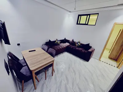 a living room with a table and a couch at IM Location Euromed Fès in Fès