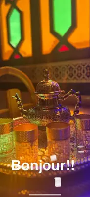 a glass tea pot sitting on top of stacks of coins at Hotel Ourida Zagora in Zagora