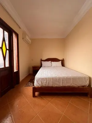 a bedroom with a bed and a large window at Hotel Ourida Zagora in Zagora