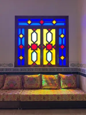 a couch in front of a stained glass window at Hotel Ourida Zagora in Zagora