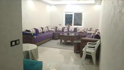 a living room with a purple couch and a table at Reda Ghazalie in Meknès