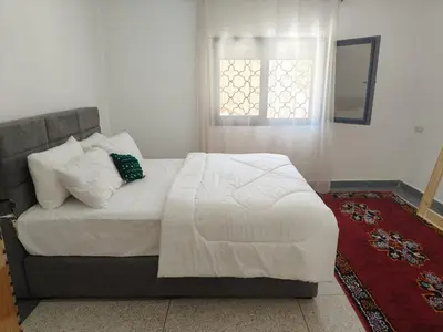 a bedroom with a large bed with a window at Apartement khadija in Azrou