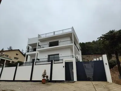 a white house with a black fence in front of it at Apartement khadija in Azrou