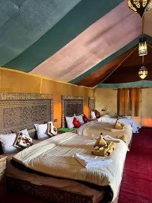 a bedroom with three beds with stuffed animals on them at Kabana Sahara Luxury Camp in Merzouga