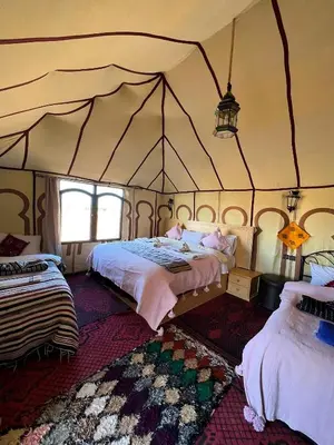 a bedroom with two beds in a tent at Kabana Sahara Luxury Camp in Merzouga