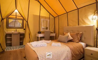a bedroom with a bed in a tent at Kabana Sahara Luxury Camp in Merzouga