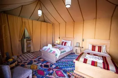 a room with two beds in a tent at Kabana Sahara Luxury Camp in Merzouga