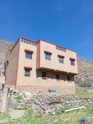 a building on top of a hill in a field at Dar Timsal in Tacheddirt