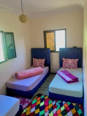 a room with two beds and a couch at Dar Timsal in Tacheddirt