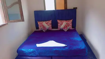 a blue bed in a small room with a window at Dar Timsal in Tacheddirt