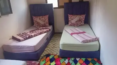 two beds sitting next to each other in a room at Dar Timsal in Tacheddirt