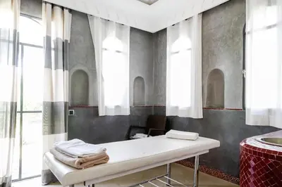 a room with a table in a room with windows at Mexance Villa with large hosting capacity, private heated pool, Fitness and SPA in Oulad Mazoug