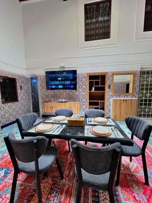 a dining room with a table and chairs at Dar Al Batoul Meknes in Meknès
