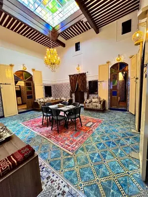 a living room with a table and chairs and a glass ceiling at Dar Al Batoul Meknes in Meknès