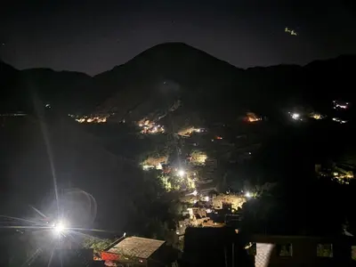 a city at night with lights on a mountain at Berber lodge amssouzart in Tizgui
