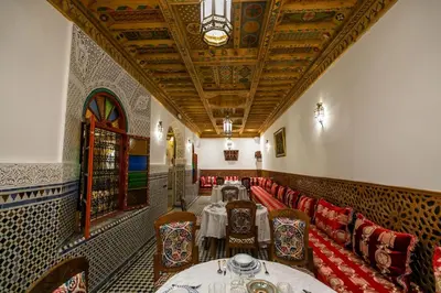 a dining room with tables and chairs and a ceiling at Riad Fes Bab Sahra Palace in Fès