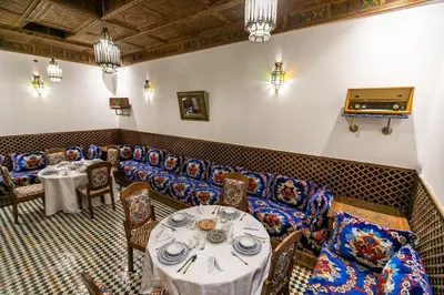 a restaurant with couches and tables and a piano at Riad Fes Bab Sahra Palace in Fès