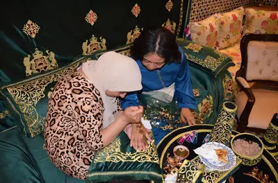 a woman standing next to a woman on a couch at Riad Fes Bab Sahra Palace in Fès