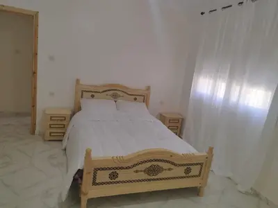 a bedroom with a bed and two night stands at Villa spacieuse 3 chambres à l'entrée de la ville in Imouzzer Kandar