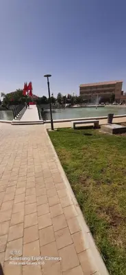 a sidewalk in a park next to a body of water at Villa spacieuse 3 chambres à l'entrée de la ville in Imouzzer Kandar