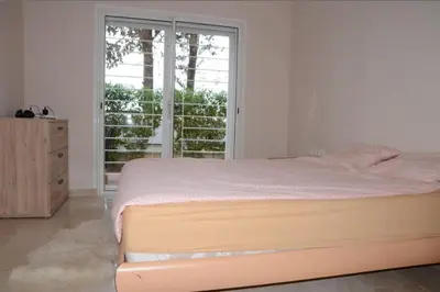 a white bedroom with a bed and a window at Apartment with large terrace and pool in Fès