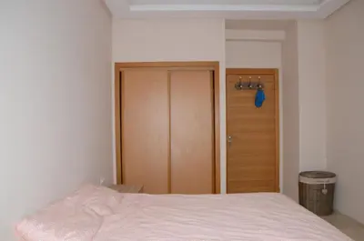a bedroom with a bed and a wooden door at Apartment with large terrace and pool in Fès
