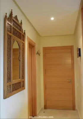 a room with a wooden door and a mirror at Apartment with large terrace and pool in Fès