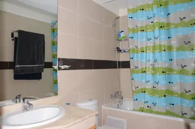 a bathroom with a sink and a shower curtain at Apartment with large terrace and pool in Fès