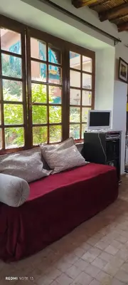 a large bed in a room with windows at Maison des maitres in Tafza
