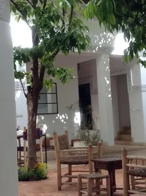 a room with a tree and tables and benches at Riad Yamcha in Meknès