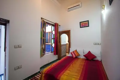 a bedroom with a bed with a colorful blanket at Dar Miouda Fes in Fès