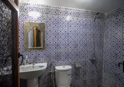 a bathroom with a toilet and a sink and a mirror at Dar Miouda Fes in Fès