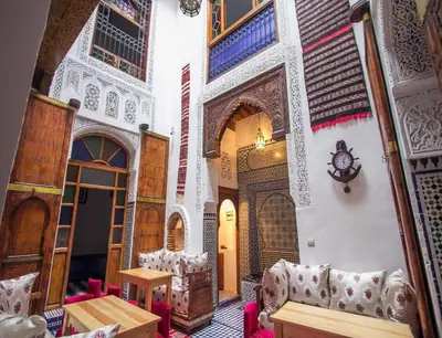 a room with a table and chairs in a building at Dar Miouda Fes in Fès