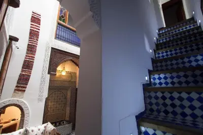a room with a staircase with blue and white tiles at Dar Miouda Fes in Fès
