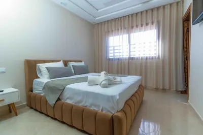 a bedroom with a bed with a teddy bear on it at Appart Hôtel Golden Sky Home in Beni Mellal