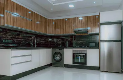 a kitchen with a washer and a stove in it at Appart Hôtel Golden Sky Home in Beni Mellal