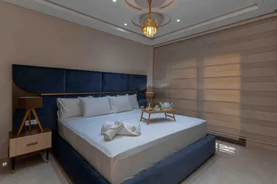 a bedroom with a large bed with a blue headboard at Appart Hôtel Golden Sky Home in Beni Mellal