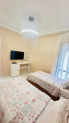 a bedroom with two beds and a television in it at Ennaim Garden Loft in Oulad Akkou