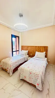 two beds sitting next to each other in a bedroom at Ennaim Garden Loft in Oulad Akkou