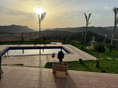 a view of a patio with a pool and palm trees at Villa en montage in Khenifra