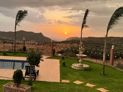 a view of the sunset from a resort with a fountain at Villa en montage in Khenifra