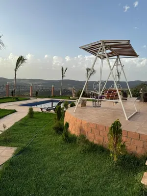 a patio with a picnic table and a metal umbrella at Villa en montage in Khenifra