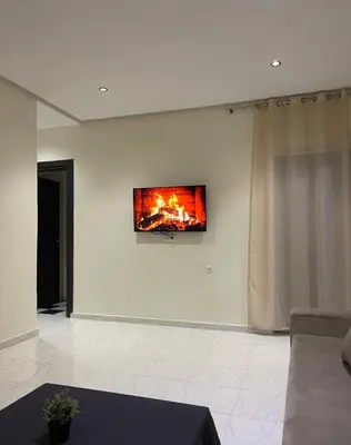 a living room with a fire on the wall at Nura Apartment - Family only in Oulad Akkou