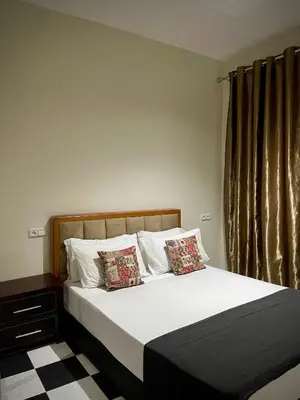 a bedroom with a bed with white sheets and pillows at Nura Apartment - Family only in Oulad Akkou