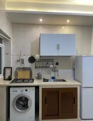a kitchen with a sink and a washing machine at Nura Apartment - Family only in Oulad Akkou
