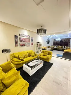 a living room with yellow couches and a table at Aicha alaoui ismaili in Fès