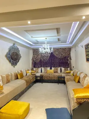 a large living room with couches and a chandelier at Aicha alaoui ismaili in Fès