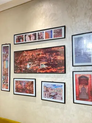 a wall with framed pictures on a wall at Aicha alaoui ismaili in Fès