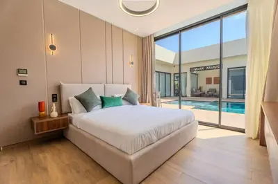 a bedroom with a large bed and a pool at Villa Famililale Shanya in Marrakech