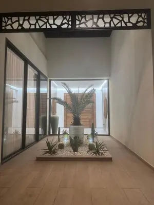 a living room with a potted plant in the middle at Villa Famililale Shanya in Marrakech